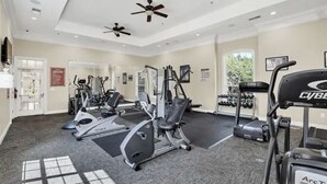 A gym with cardio machines, weightlifting equipment, and dumbbells. - Gorgeous Condo in Prestigious Championsgate Golf Resort Community w View of Pool (Championsgate)