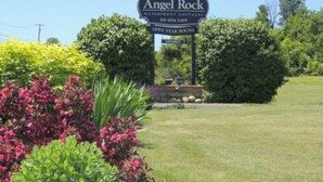 Cartel de Angel Rock Waterfront Cottages con un número de teléfono y aviso de que está abierto todo el año.