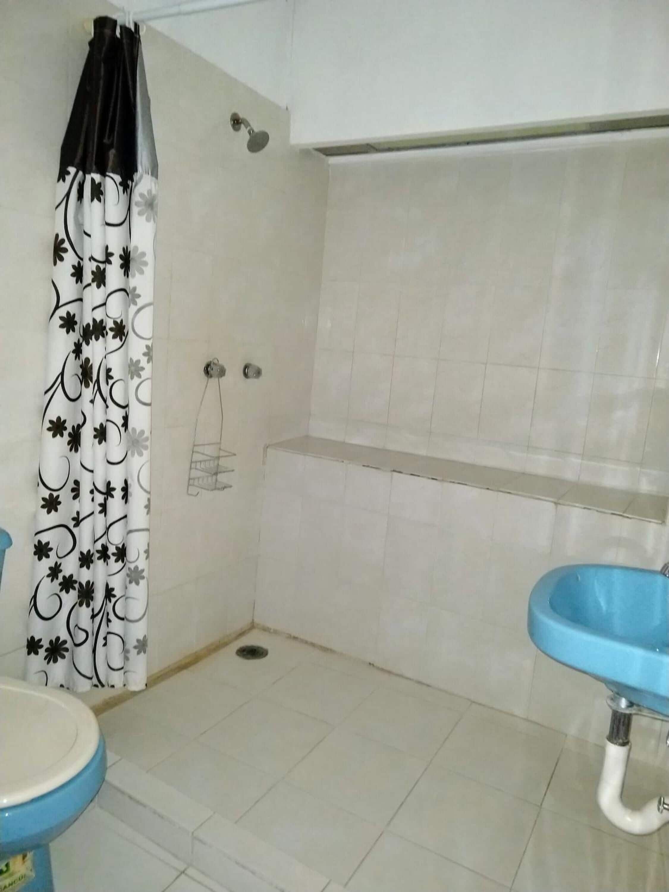 A bathroom with a shower, a toilet, and a sink.