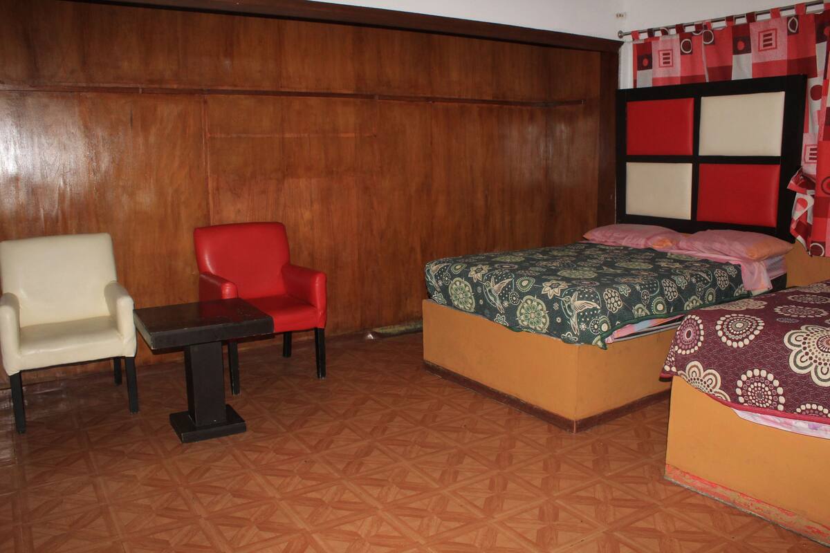 A room with a bed, a chair, and a small table.