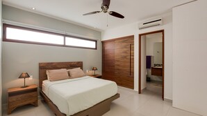 A modern bedroom with a bed, nightstands, a ceiling fan, and a large window. - Luxe Tao Riviera Resort Condo w/ Beach & Golfing! (Solidaridad)