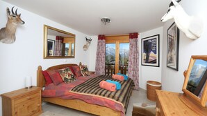 Une chambre à coucher avec un lit en bois, une table de chevet, une commode et un miroir.