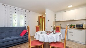 Um espaço de estar compacto com área de jantar, sofá e kitchenette.