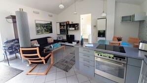 Une cuisine moderne dotée d’un four encastré et d’un coin repas avec une table et des chaises.