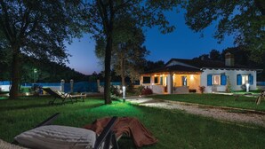 A house with a patio area, a lawn, and a fence.