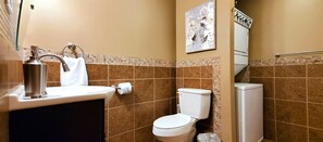 A bathroom with a sink, toilet, and a shower area.