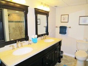 Een bad/douchecombinatie, een haardroger, handdoeken, zeep