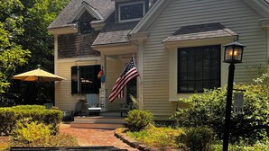 A house with a front porch, an American flag, and a bench. - The Perfect Location to relax and explore all that the Seacoast has to offer!  (Eliot)