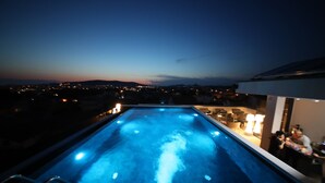 A rooftop pool with a view of the city at dusk. - Hotel Scala dOro (Vodice)