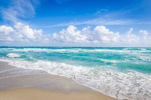 Una playa con olas y un cielo despejado.