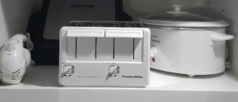 Une cuisine équipée d’un grille-pain ProctorSilex, d’un mixeur, d’une machine à café et d’un cuiseur à riz.