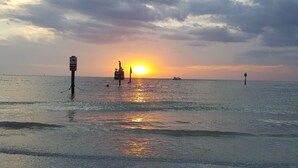 A sunset over a calm sea with a pier extending into the water. - Classy & Clean Pet Friendly (Clearwater)