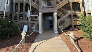 A multi-story building with a central staircase, wooden railings, and a covered walkway. - 2 Bed, 2 Bath Condo with an Oceanfront Pool and Ocean View from the Unit. (Kill Devil Hills)