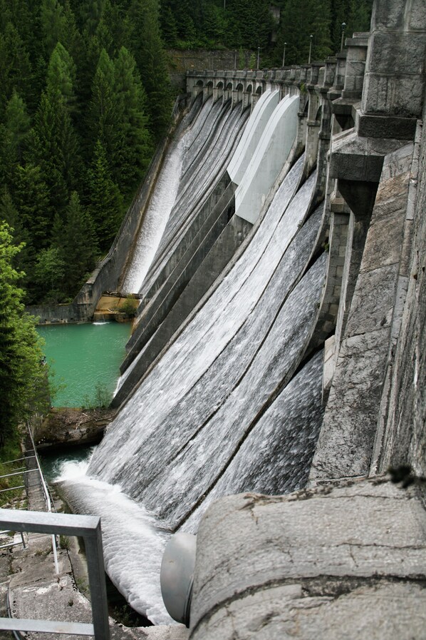 Un grand barrage doté de plusieurs canaux d’eau et d’un petit plan d’eau à sa base.