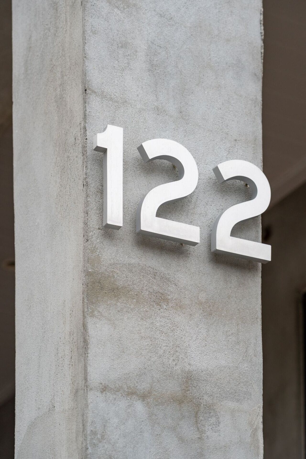 A concrete pillar with the numbers '122' mounted on it.