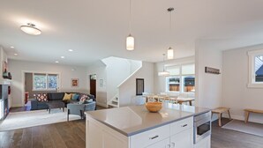 A modern kitchen with white cabinets, a central island, and pendant lighting. - Hillside Haven - Bend's West Side, Work-from-Home Office, New, Modern, Light, Bright (Bend)