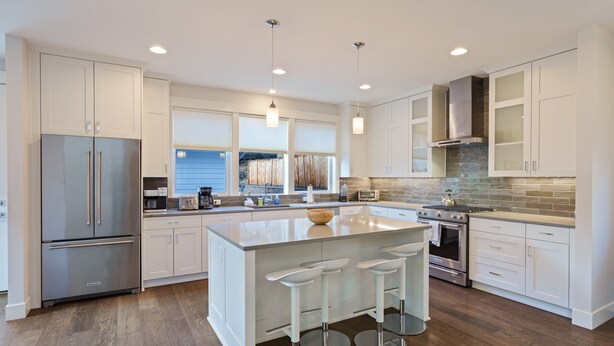 A modern kitchen with a large island, stainless steel appliances, and a stone backsplash. - Hillside Haven - Bend's West Side, Work-from-Home Office, New, Modern, Light, Bright (Bend)