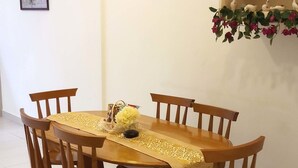 Un comedor con una mesa redonda de madera, seis sillas y un camino de mesa decorativo.