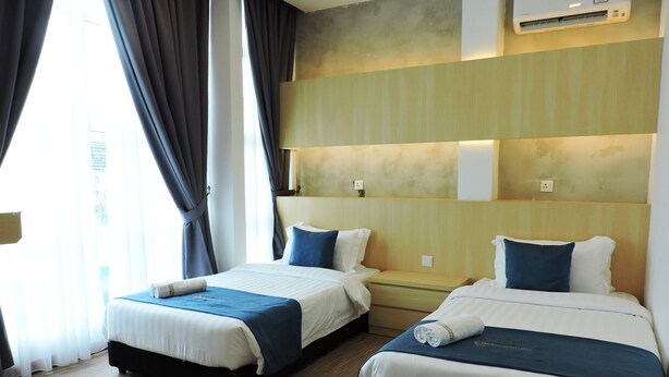 A hotel room with two beds, a large window with curtains, an air conditioning unit, and a wooden floor. - My Rainforest Suite Hotel (Langkawi)
