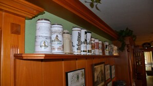 A shelf with various beer cans and a framed picture.