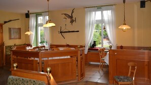 A dining area with wooden furniture, pendant lights, and a view of the outdoors.