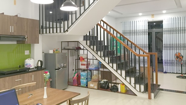 Una cocina moderna con comedor, una escalera y una sala de estar.