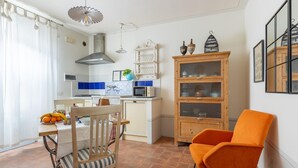 A compact kitchen with a dining area, featuring a wooden cabinet with glass doors, a microwave, and a fruit bowl on the counter. - Beautiful apartment in S.Rocco di Larciano PT with WiFi (S.Rocco di Larciano PT)