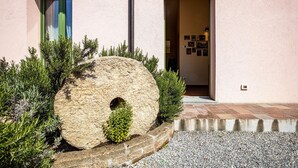 A building with a large stone sculpture in the foreground, a door with a blue curtain, and a wall with framed pictures. - Stunning home in Ponte Buggianese (Ponte Buggianese)