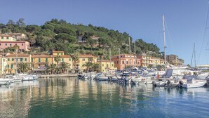 A marina with numerous boats docked, surrounded by colorful buildings and a hillside in the background. - 2 bedroom amazing apartment in Porto Azzurro (Porto Azzurro)