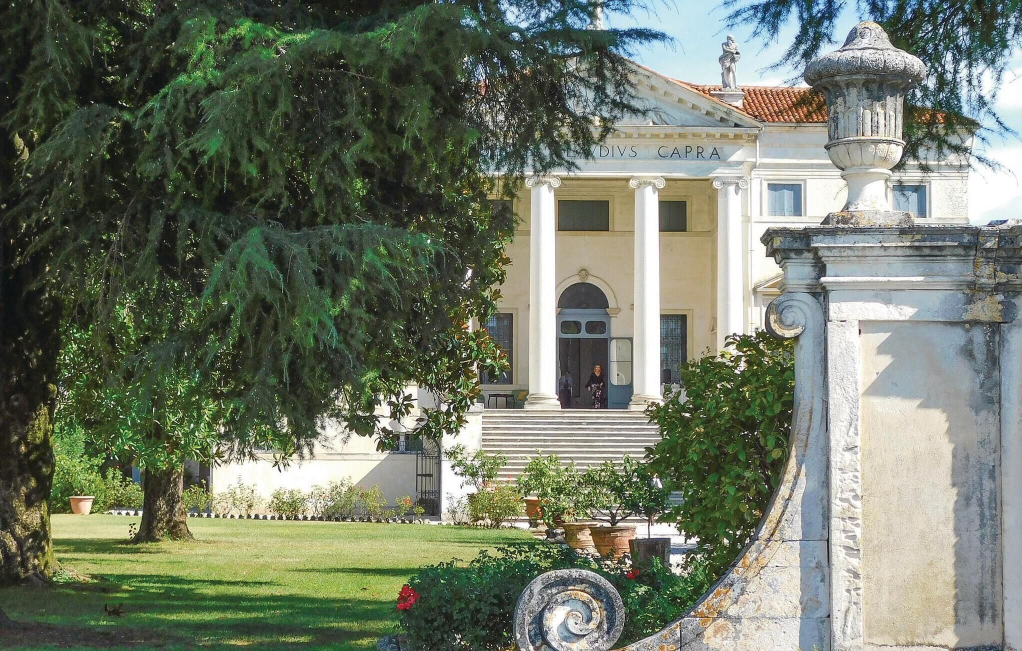 Ein prachtvolles Gebäude mit einer klassischen Fassade, großen Säulen und einem gepflegten Garten.