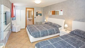 A hotel room with two beds, a television, a mirror, and a bathroom with a sink and toilet. - 2 bedroom pet friendly apartment in Tremosine -BS- (Tremosine -BS-)