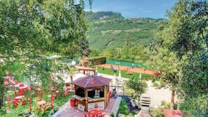 A gazebo with a red roof and a grill station in a lush, green outdoor setting. - 2 bedroom pet friendly apartment in Tremosine -BS- (Tremosine -BS-)