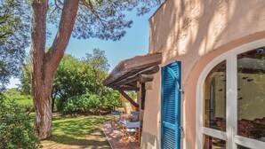 A rustic building with a covered patio, outdoor seating, and a large window. - Stunning home in Castiglione d. Pescaia (Castiglione d. Pescaia)