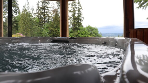 A hot tub with a view of trees and mountains. - Cascades View A Frame (Snohomish)