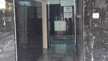 Una entrada con piso de mármol negro que conduce a una zona de recepción.