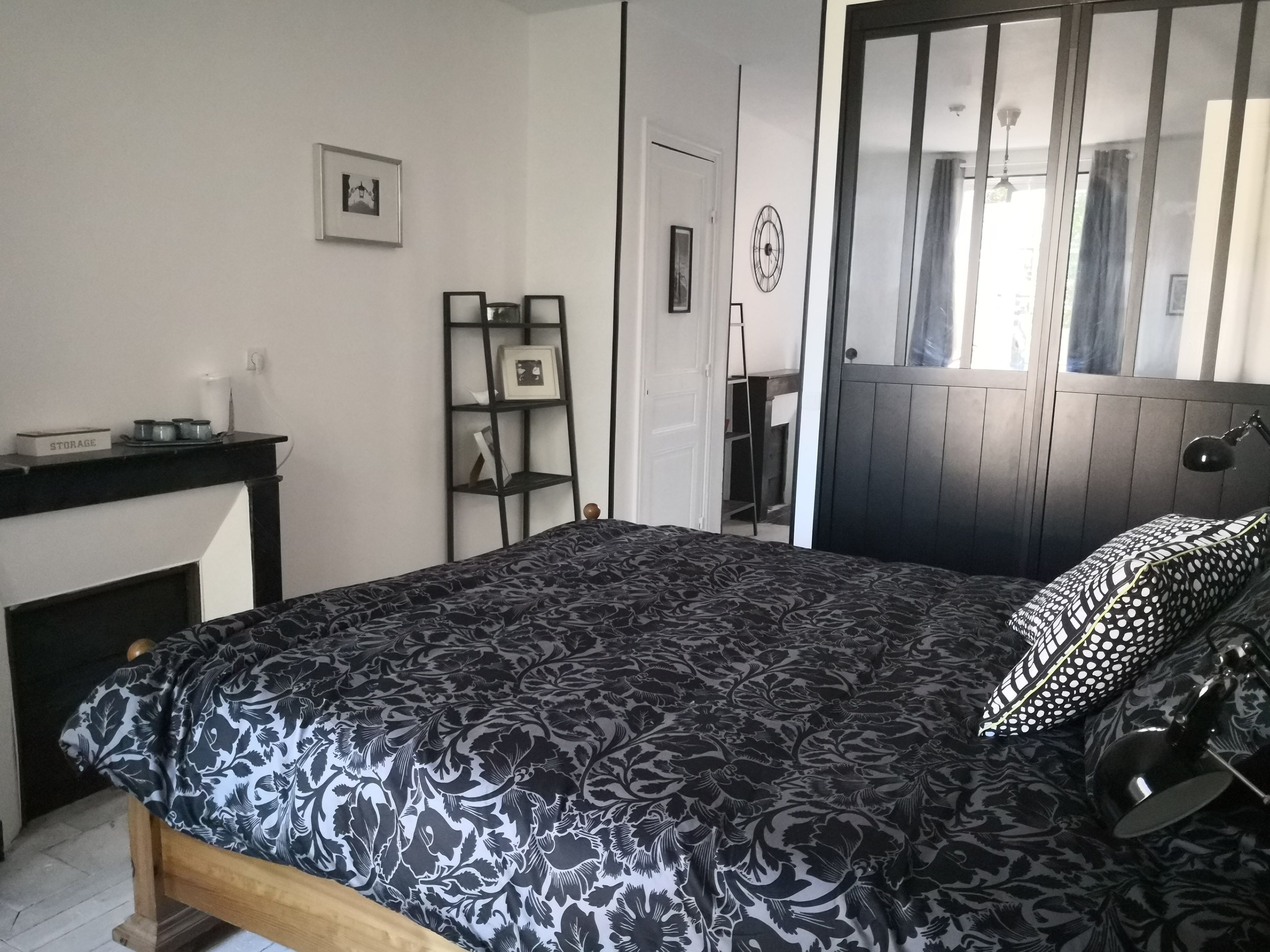 A bedroom with a bed, a desk, a chair, and a wardrobe.