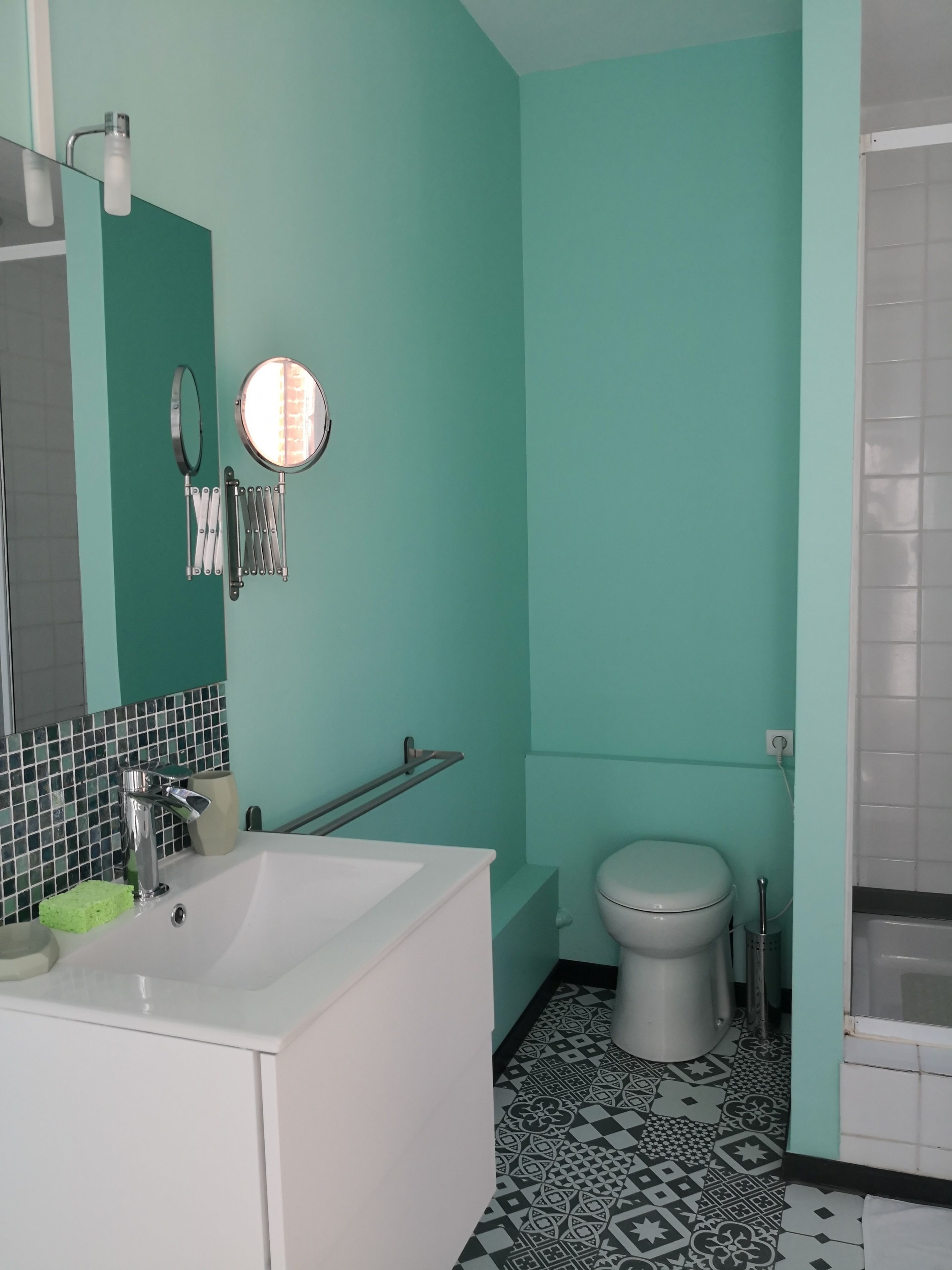 A bathroom with a white sink, a mirror, a toilet, and a bathtub.
