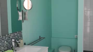 A bathroom with a white sink, a mirror, a toilet, and a bathtub.