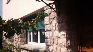 Fachada de piedra con una ventana y una puerta.