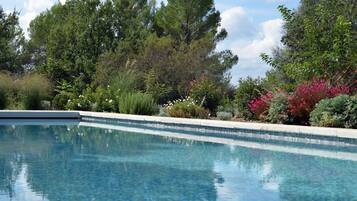 Een seizoensgebonden buitenzwembad en parasols bij het zwembad