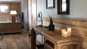 A rustic wooden bench with candles, a wooden floor, and a wall-mounted mirror. - Chalet d'exception**** with wellness area (Villard reculas)