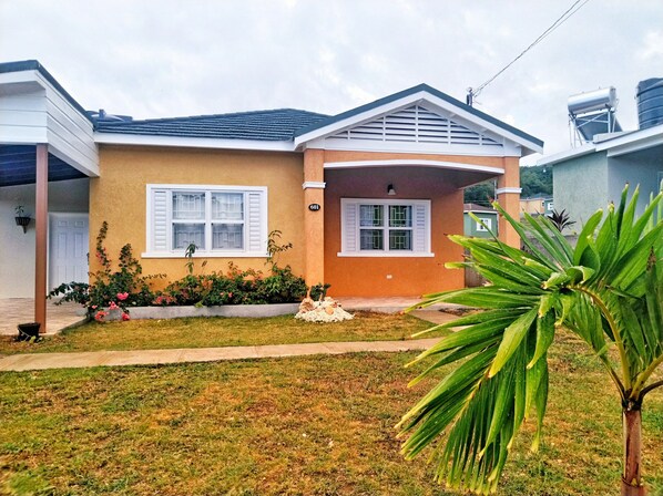 A single-story house with a front porch, a small garden, and a visible number '601' on the wall. - The Sojourn at the Vistas (Runaway Bay)