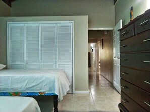 A bedroom with a bed, a dresser, and a closet. - The Sojourn at the Vistas (Runaway Bay)