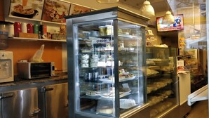 A bakery with a glass display case filled with various baked goods. - Cute Abasto Apartment (Buenos Aires)