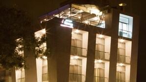 Un edificio de varios pisos con un diseño arquitectónico moderno, con amplios ventanales y una entrada destacada.