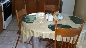 Una cocina con armarios de madera, estufa, microondas, fregadero y refrigerador.