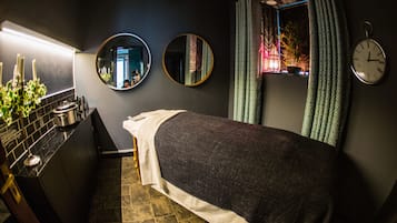 A compact room with a bed, a small kitchenette, and a window with curtains.
