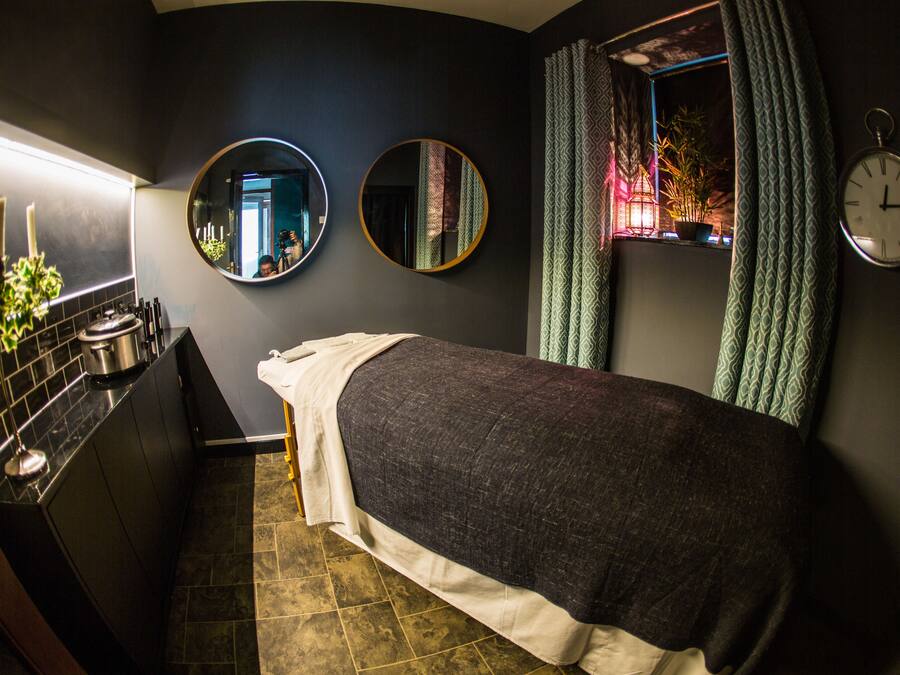A compact room with a bed, a small kitchenette, and a window with curtains.