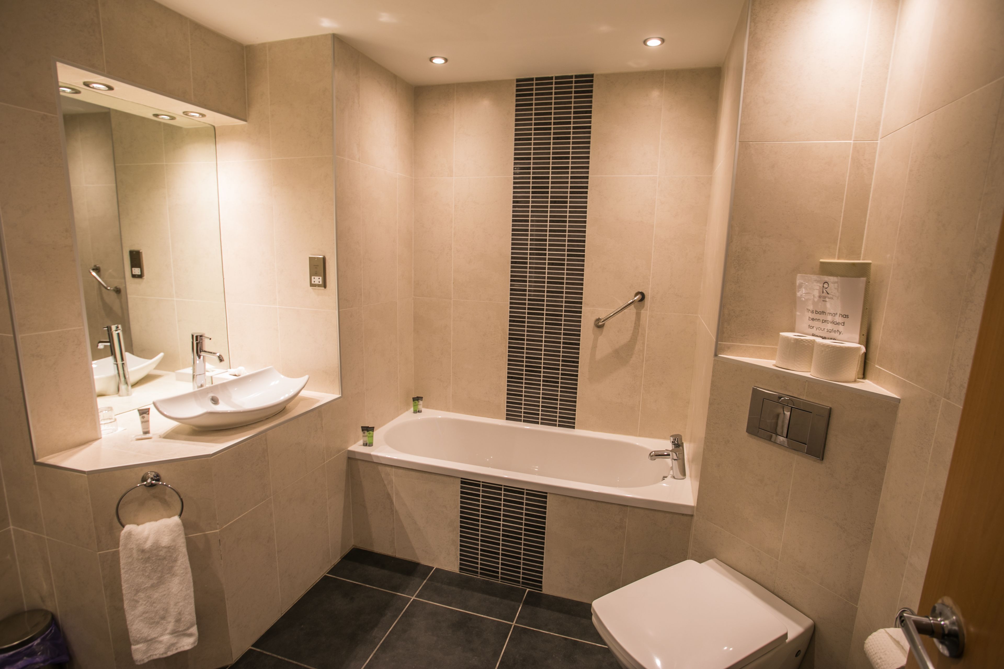 Ein modernes Badezimmer mit einer Badewanne, einer Toilette und einem Waschbecken.