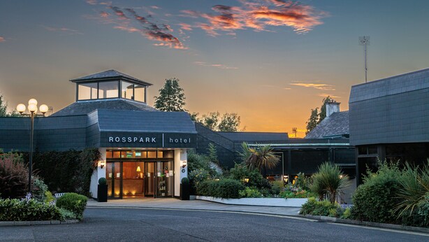 The exterior of the Rosspark hotel with a glass entrance, a covered area, and a landscaped garden. - Rosspark Hotel (Ballymena)